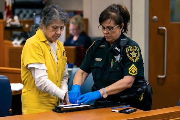 Susan Lorincz, left, who fatally shot a Black neighbor through her front door during an ongoing dispute, is finger printed after she was sentenced to 25 years in prison at a court hearing Monday, Nov. 25, 2024, in Ocala, Fla. (Doug Engle/Ocala Star-Banner via AP, Pool)