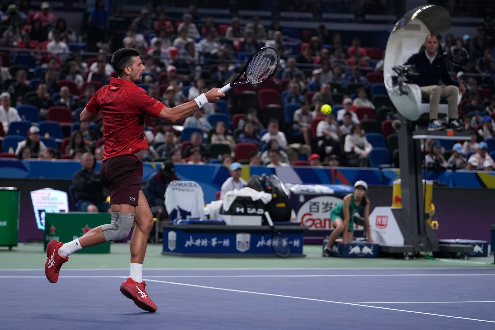 Novak Djokovic of Serbia plays a forehand return against Jake Mensik of the Czech Republic during the men's singles quarterfinals match in the Shanghai Masters tennis tournament at Qizhong Forest Sports City Tennis Center in Shanghai, China, Friday, Oct. 11, 2024. (AP Photo/Andy Wong)