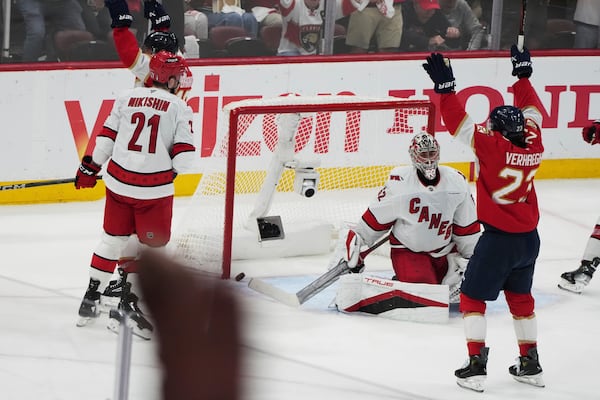 The puck gets past Carolina Hurricanes goaltender Pyotr Kochetkov, center, on a goal scored by Florida Panthers' Aleksander Barkov during the third period in Game 3 of the NHL hockey Stanley Cup Eastern Conference finals Saturday, May 24, 2025, in Sunrise, Fla. (AP Photo/Lynne Sladky)