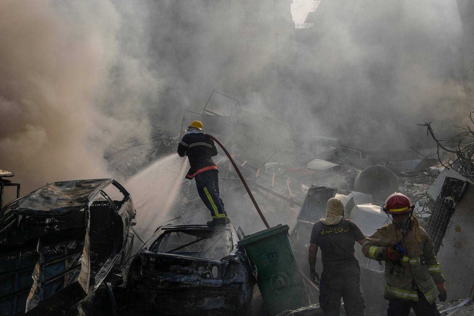 Civil defense workers extinguish a fire as smoke rises from the site of an Israeli airstrike in Dahiyeh, Beirut, Lebanon, Friday, Nov. 1, 2024. (AP Photo/Hassan Ammar)