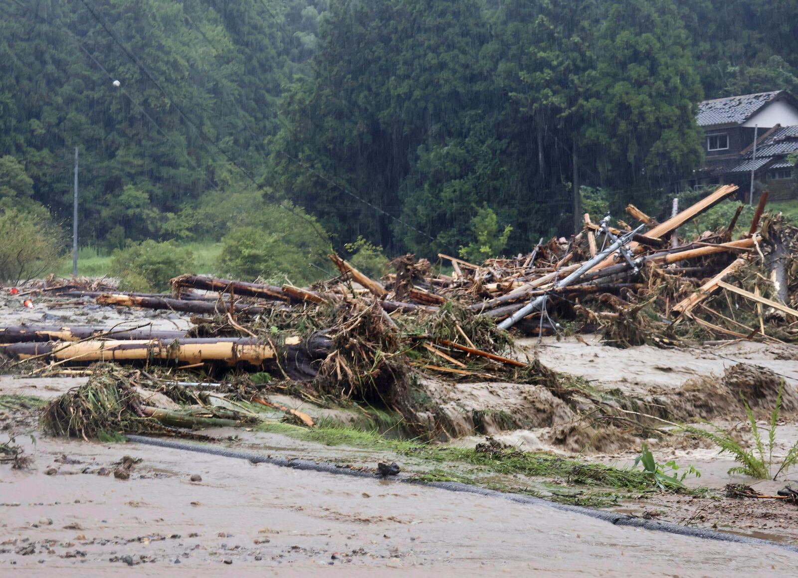 Debris is piled in a river running through Wajima, Japan, Sunday, Sept. 22, 2024, following heavy rain in central Japan's Noto peninsula area, where a devastating earthquake took place on Jan. 1. (Katsunori Nishioka/Kyodo News via AP)