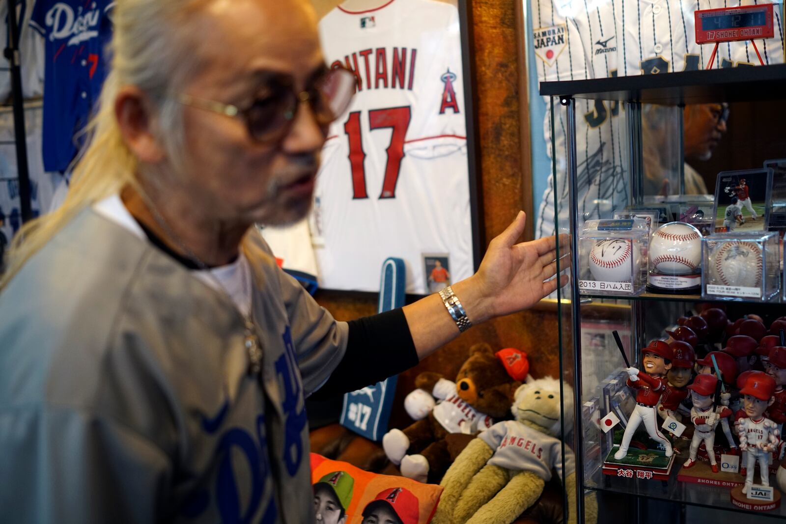 Hironobu Kanno, representative of a private fan club of Shohei Ohtani of the Los Angeles Dodgers, shows his collection items at his beauty salon in Oshu, northeastern Japan, the hometown of Ohtani, Tuesday, Oct. 29, 2024. (AP Photo/Eugene Hoshiko)