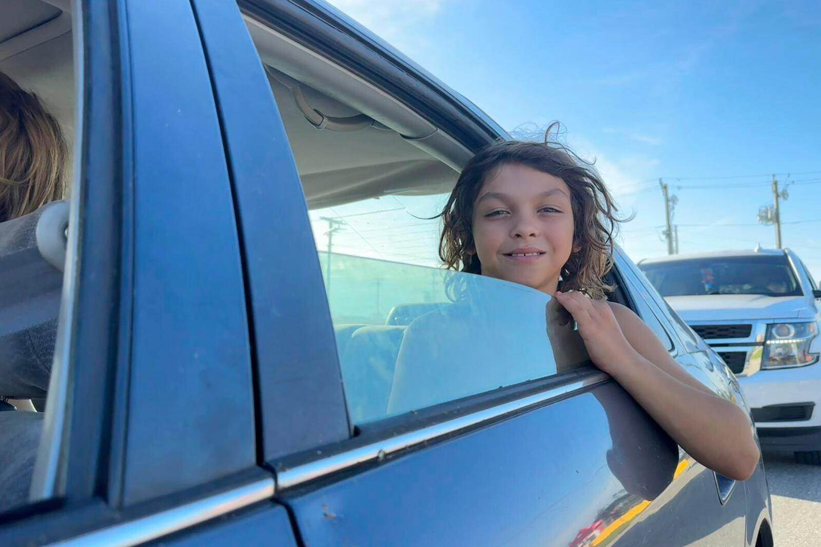 Dooley Land, 10, waits in a food distribution line with his family in Perry, Fla., in the aftermath of Hurricane Helene on Saturday Sept. 28, 2024. (AP Photo/Kate Payne)