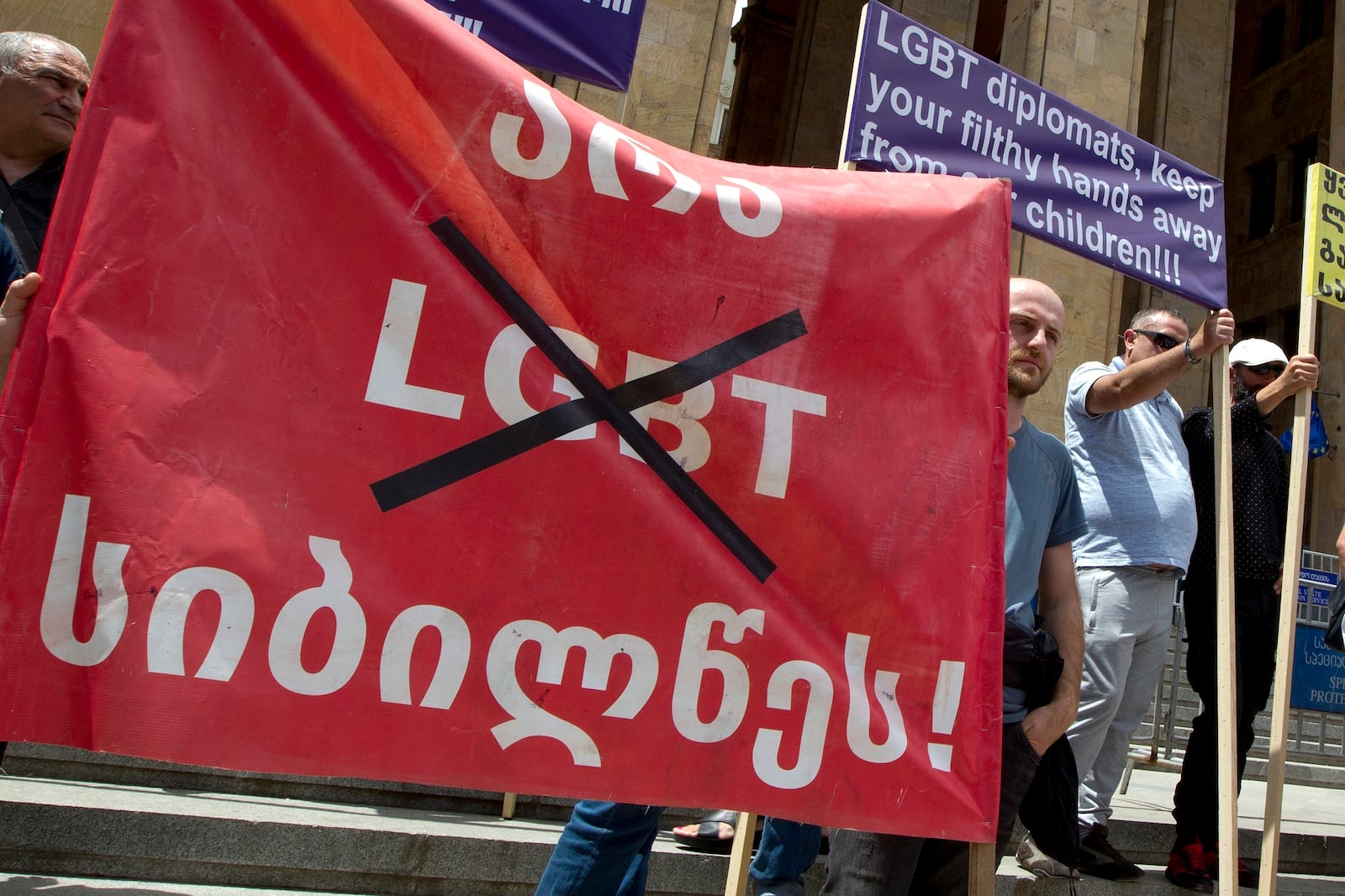 FILE - Georgian far right parties and their supporters hold a banner that reads: "No to LGBT darkness," in front of the parliament during a rally against Pride Week in Tbilisi, Georgia, on July 2, 2022. (AP Photo/Shakh Aivazov, File)