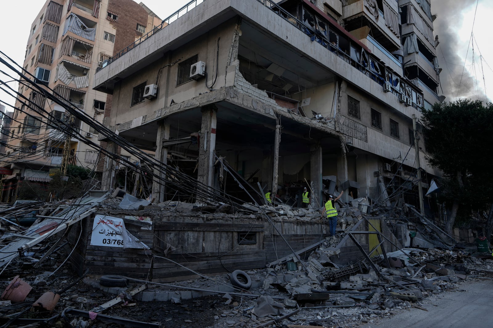 Emergency workers inspect a building that was hit in an Israeli airstrike in Dahiyeh, Beirut, Lebanon, Sunday, Oct. 6, 2024. (AP Photo/Bilal Hussein)