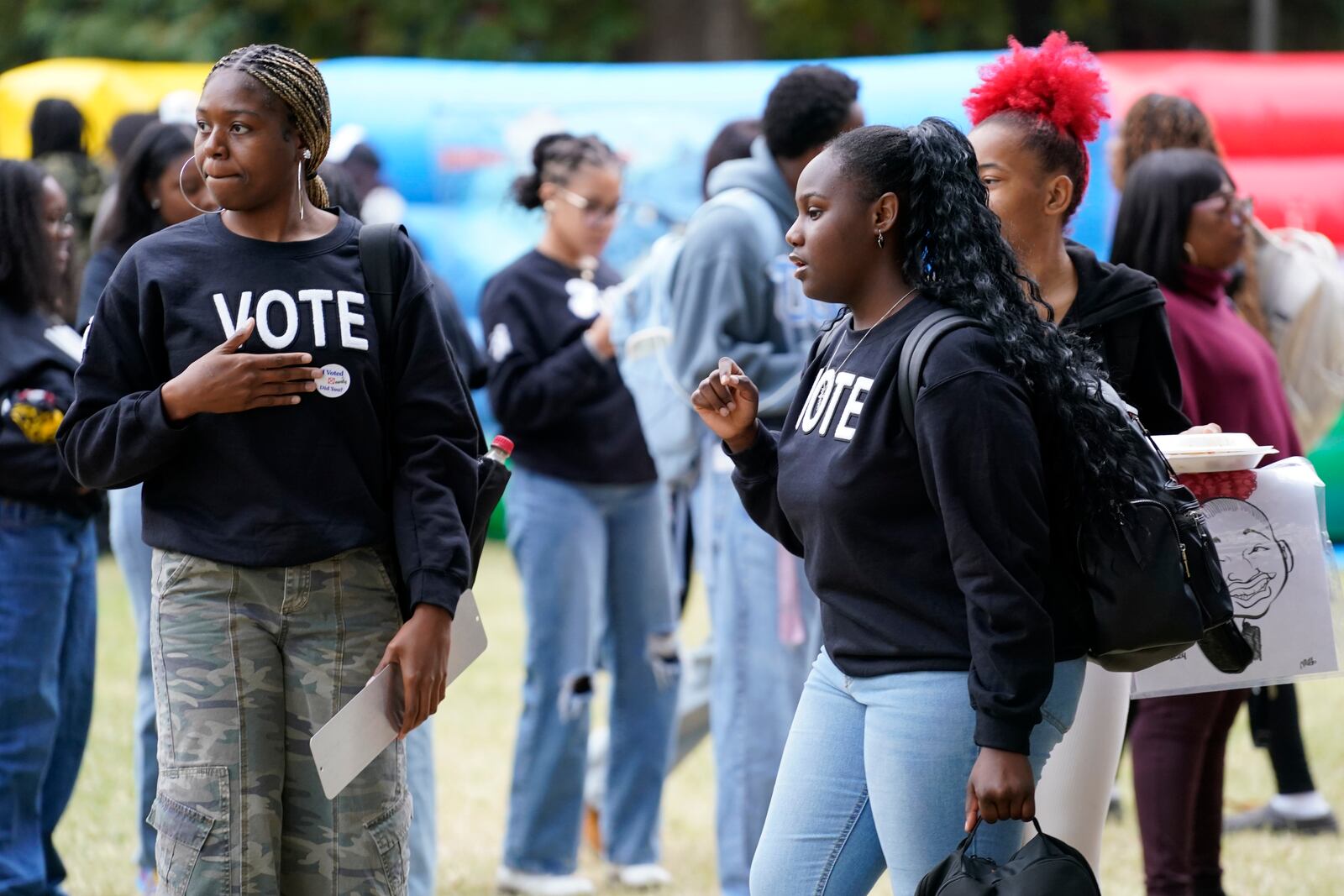 Tamera Drain, left, and Lauren Miller, right, chat during a get out the vote rally at North Carolina A&T in Greensboro, N.C., Monday, Oct. 28, 2024. (AP Photo/Chuck Burton)