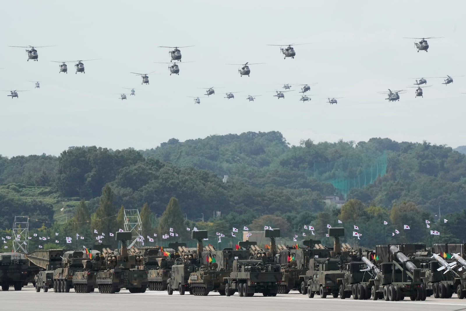 South Korean military helicopters fly over armored vehicles during the media day for the 76th anniversary of Armed Forces Day at Seoul air base in Seongnam, South Korea, Wednesday, Sept. 25, 2024. (AP Photo/Ahn Young-joon)