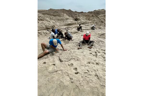 Scientists study fossil footprints for clues about co-existing species of early human ancestors at the excavation site on the eastern side of Lake Turkana in northern Kenya, in 2022. (Neil Thomas Roach via AP)