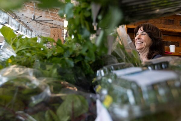Alison Venuti, who goes by Sunny, an employee of Bolton Farms, laughs as she speaks with a customer at the Rochester Public Market on Saturday, March 22, 2025, in Rochester, N.Y. (Caitlyn Daproza via AP)