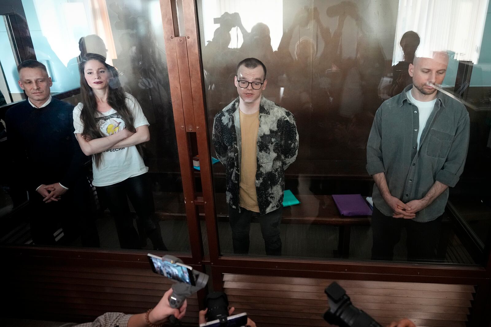 Russian journalists, from left: Konstantin Gabov, Antonina Favorskaya, Artyom Kriger and Sergey Karelin, accused of working for a group founded by the late Russian opposition politician Alexei Navalny, stand in a defendant's cage of the Nagatinsky District Court in Moscow, Russia, on Wednesday, Oct. 2, 2024. (AP Photo)