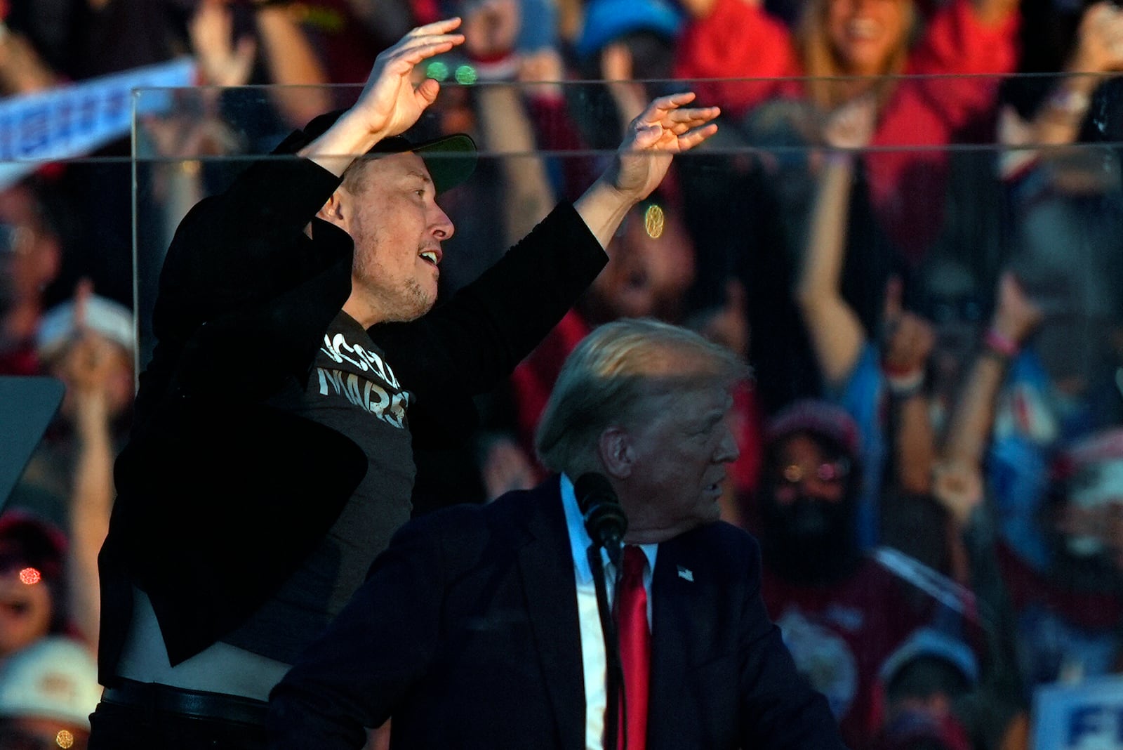 Elon Musk jumps on the stage behind Republican presidential nominee former President Donald Trump during a campaign rally at the Butler Farm Show, Saturday, Oct. 5, 2024, in Butler, Pa. (AP Photo/Julia Demaree Nikhinson)