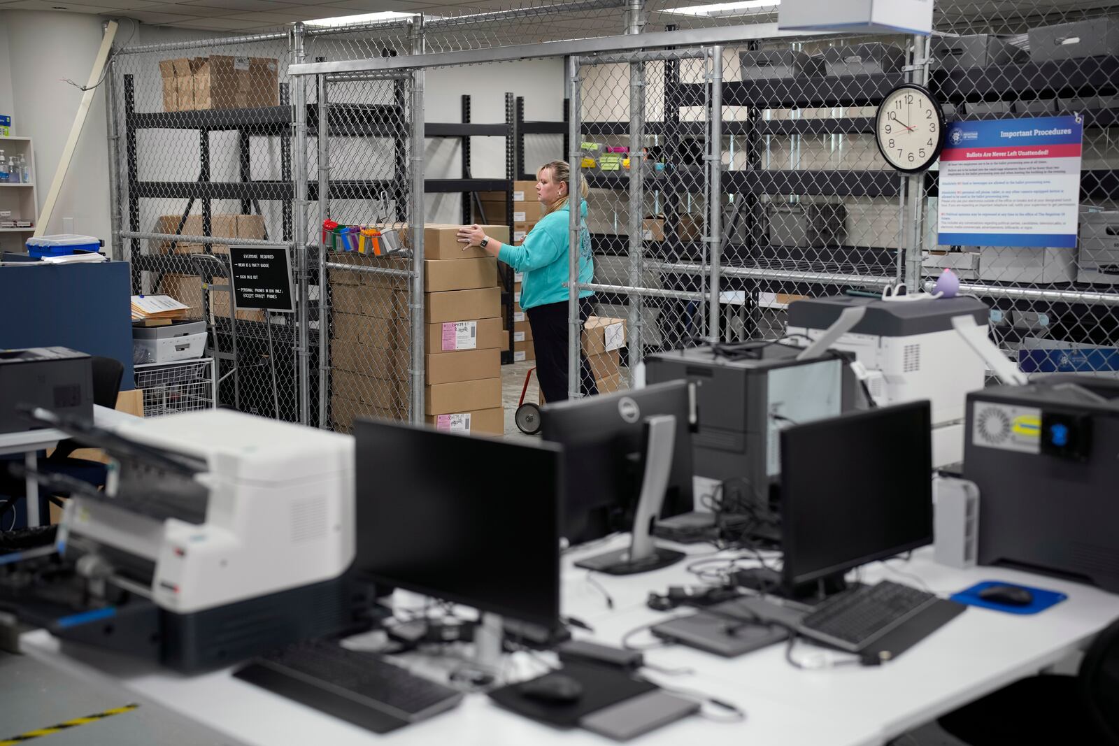 Cari-Ann Burgess, interim Registrar of Voters for Washoe County, Nev., moves around boxes while preparing the office for elections Saturday, Sept. 21, 2024, in Reno, Nev. (AP Photo/John Locher)