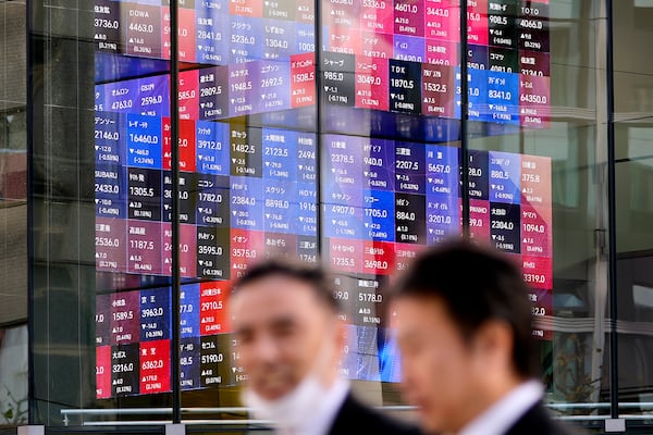 People walk past an electronic stock board showing Japan's stock prices Thursday, Nov. 28, 2024 in Tokyo.(AP Photo/Shuji Kajiyama)