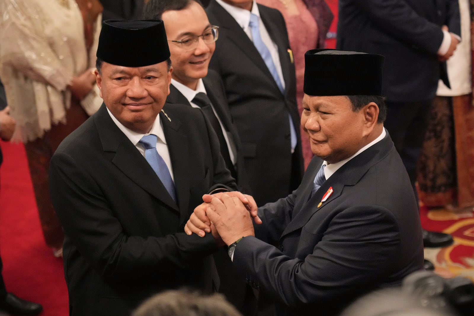 Indonesian President Prabowo Subianto, right, congratulates newly-appointed Coordinating Minister for Political and Security Affairs Budi Gunawan during the swearing-in ceremony of the new cabinet ministers at the presidential palace in Jakarta, Indonesia, Monday, Oct. 21, 2024. (AP Photo/Achmad Ibrahim)