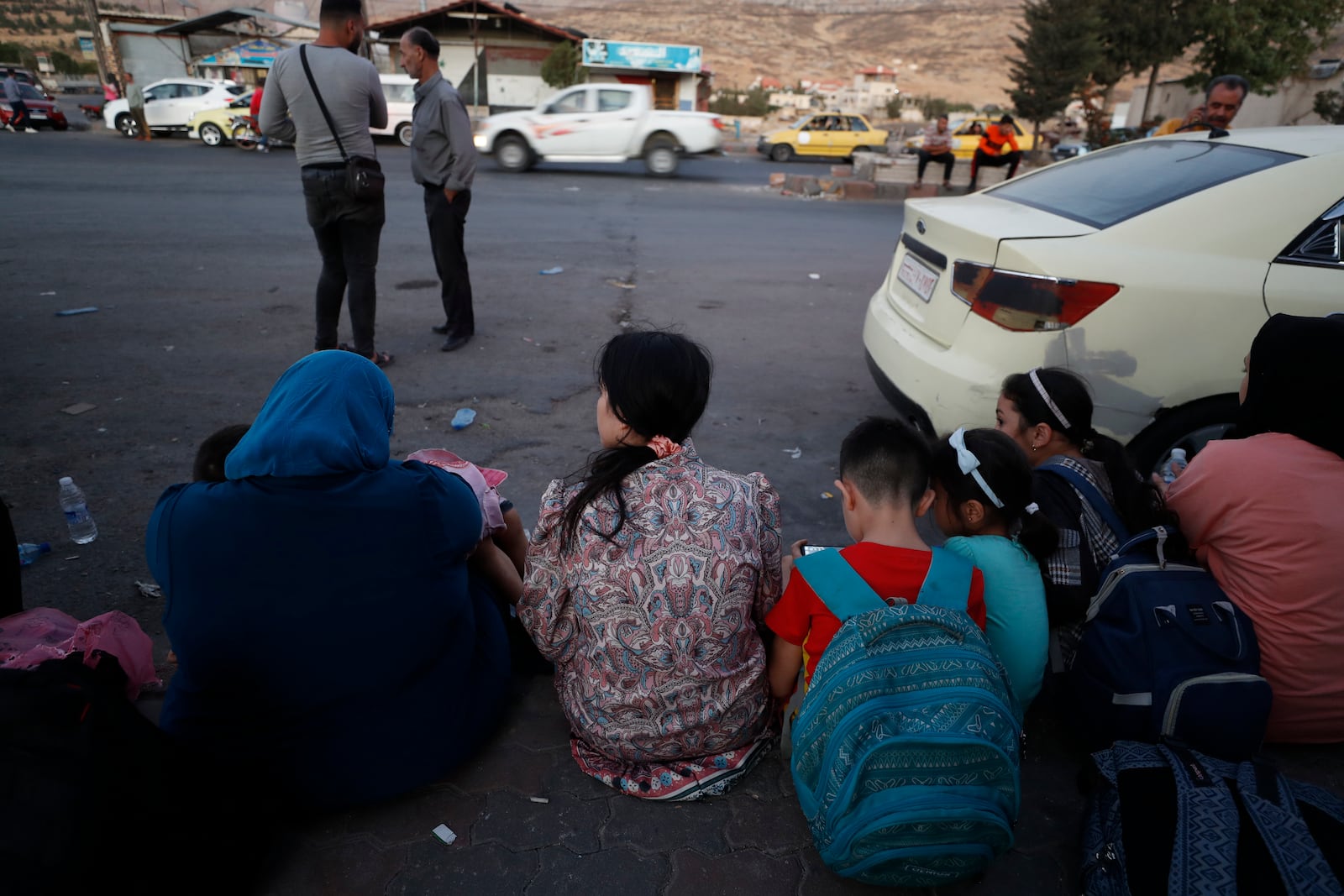 Lebanese fleeing the Israeli bombardment, sit on the ground as they arrive at the Syrian-Lebanese border crossing in Jdaidet Yabous, Syria, Tuesday, Sept. 24, 2024. (AP Photo/Omar Sanadiki)