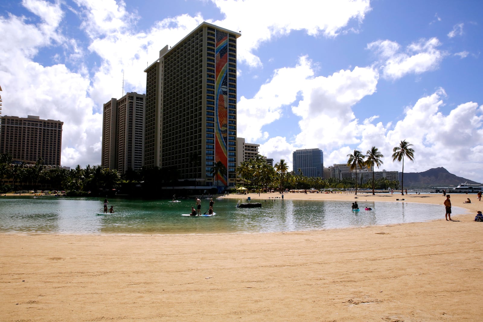 FILE - People swim in the lagoon in front of the Hilton Hawaiian Village resort in Honolulu on Saturday, Sept. 4, 2021. (AP Photo/Caleb Jones, File)