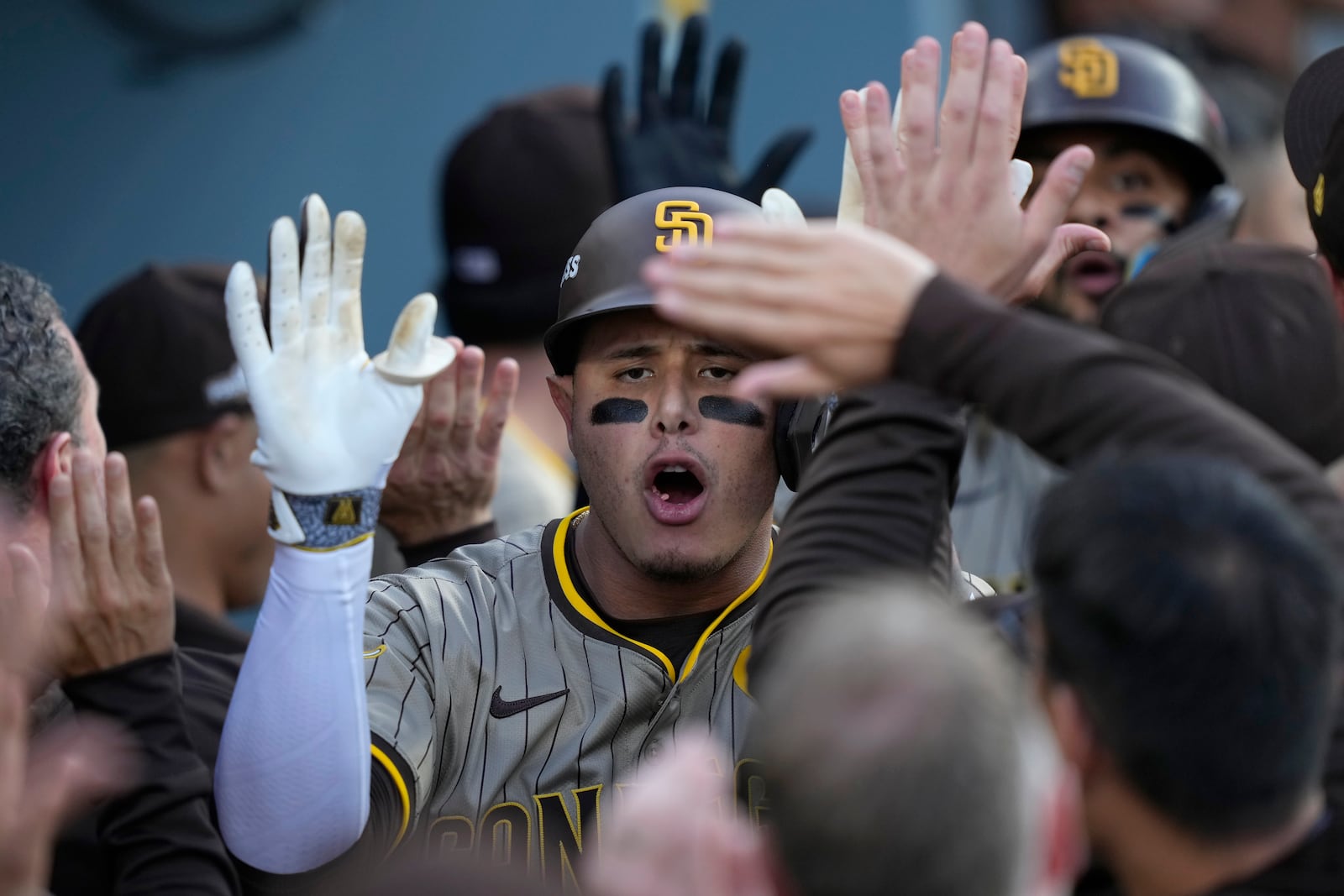 San Diego Padres' Manny Machado, middle, celebrates in the dugout after his two-run home run during the first inning in Game 1 of baseball's NL Division Series against the Los Angeles Dodgers, Saturday, Oct. 5, 2024, in Los Angeles. (AP Photo/Mark J. Terrill)