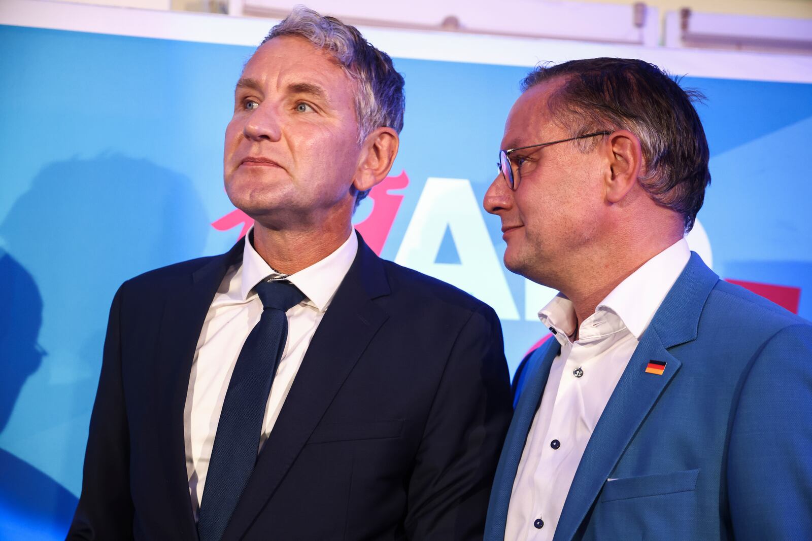 Right-wing Alternative for Germany (AfD) party co-leader Tino Chrupalla, right, and Thuringia AfD party leader Bjoern Hoecke, left, react after first exit polls of the Brandenburg state election in Potsdam, Germany, Sunday, Sept. 22, 2024. (Liesa Johannssen/Pool Photo via AP)