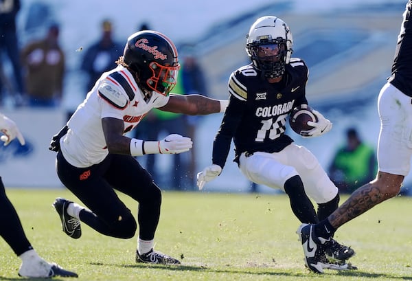 Oklahoma State safety Dylan Smith, left, pursues Colorado wide receiver LaJohntay Wester after he pulled in a pass in the first half of an NCAA college football game Friday, Nov. 29, 2024, in Boulder, Colo. (AP Photo/David Zalubowski)