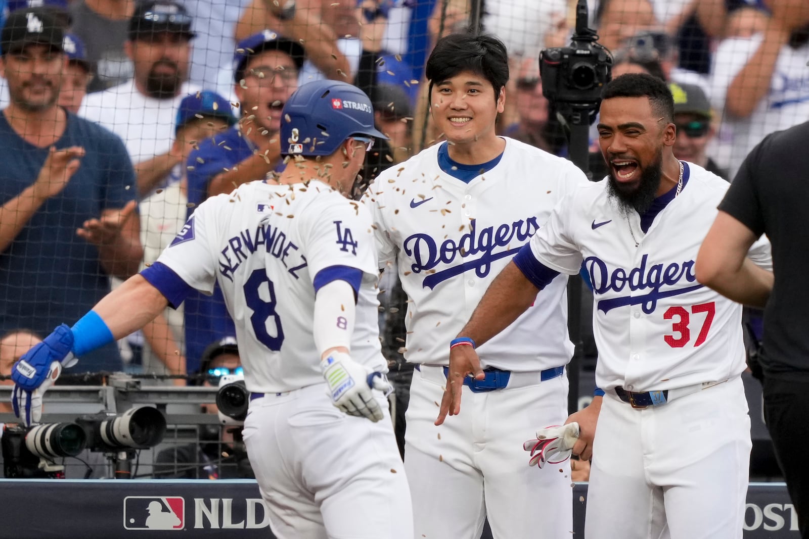 Los Angeles Dodgers' Kiké Hernández (8) celebrates his solo home run with Shohei Ohtani, center, and Teoscar Hernández during the second inning in Game 5 of a baseball NL Division Series against the San Diego Padres, Friday, Oct. 11, 2024, in Los Angeles. (AP Photo/Mark J. Terrill)