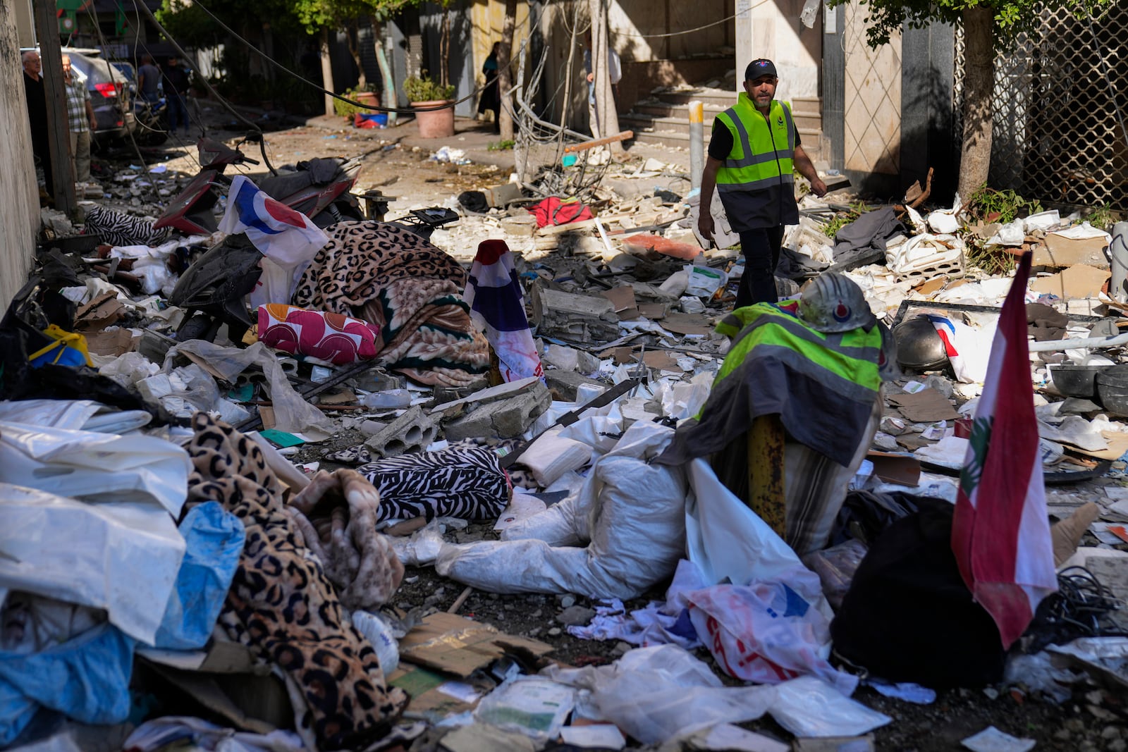 A Hezbollah paramedic walks between debris after an airstrike hit an apartment in a multistory building, in central Beirut, Lebanon, Thursday, Oct. 3, 2024. (AP Photo/Hussein Malla)