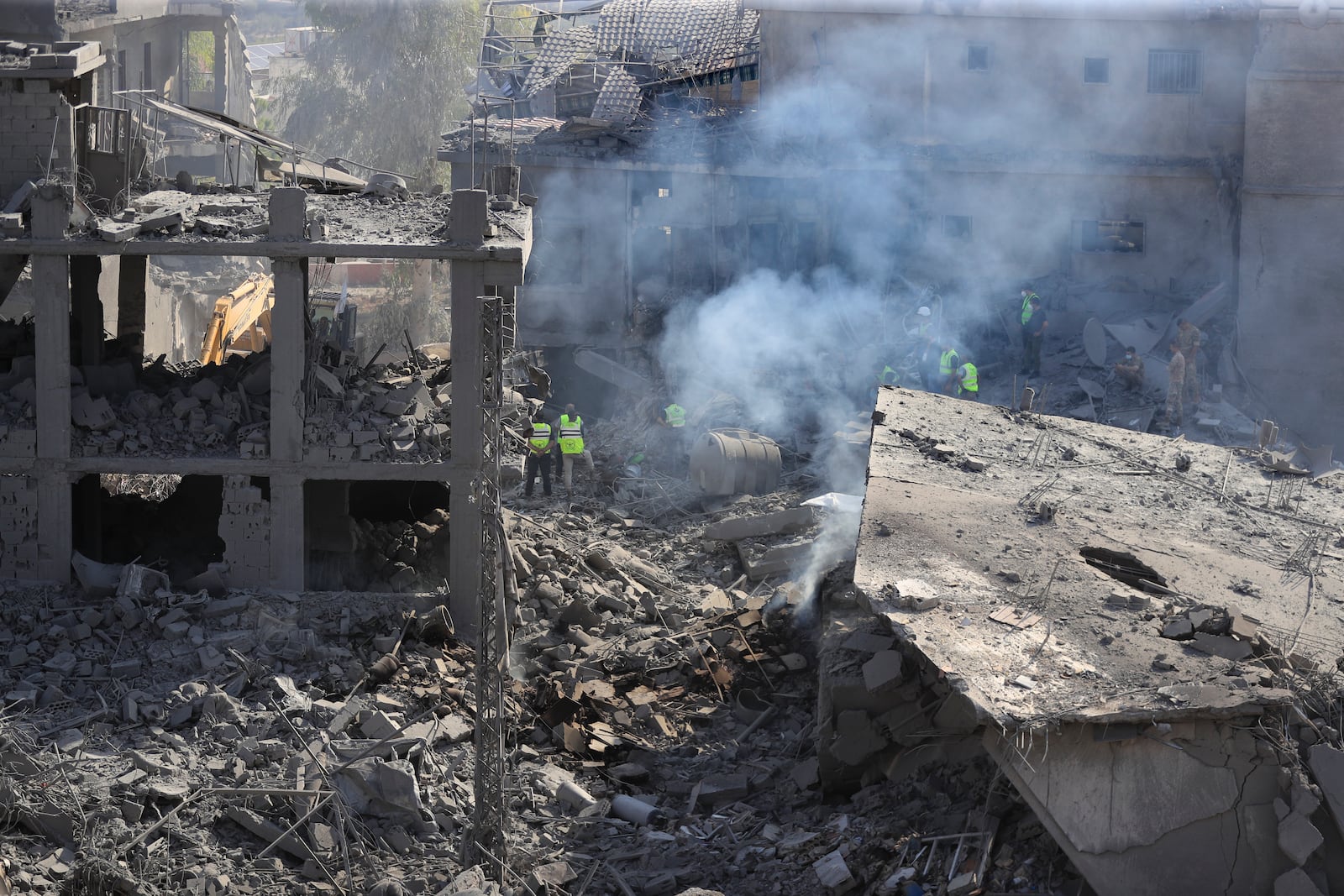 Rescue workers search for victims at the site that was hit by Israeli airstrikes in Qana village, south Lebanon, Wednesday, Oct. 16, 2024. (AP Photo/Mohammed Zaatari)