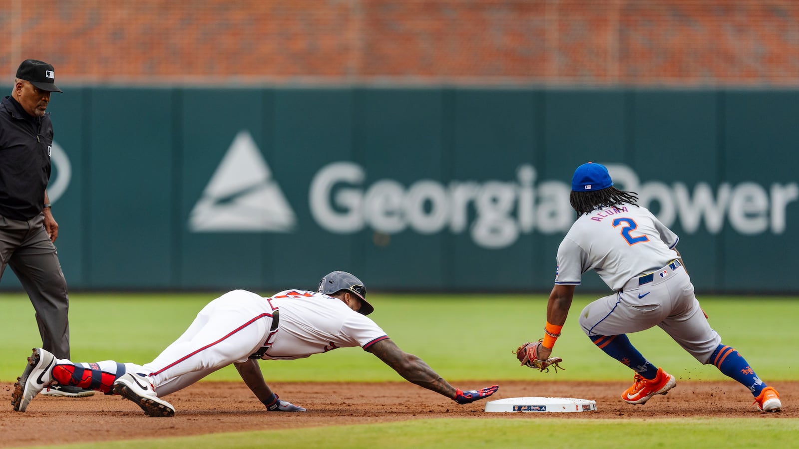 Atlanta Braves' Jorge Soler, left, slides into second base before New York Mets shortstop Luisangel Acuna, right, can tag him in the second inning of the second baseball game of a doubleheader, Monday, Sept. 30, 2024, in Atlanta. (AP Photo/Jason Allen)