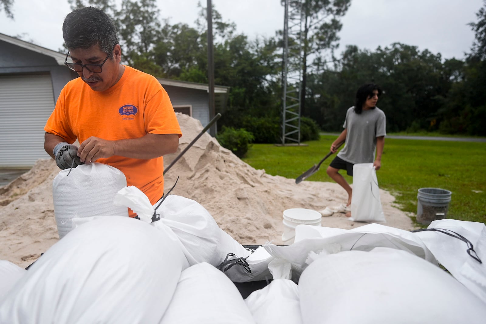 Jose Gonzales and his son Jadin Gonzales, 14, fill sand bags ahead of Hurricane Helene, expected to make landfall Thursday evening, Thursday, Sept. 26, 2024, in Clyattville, Ga. (AP Photo/Mike Stewart)