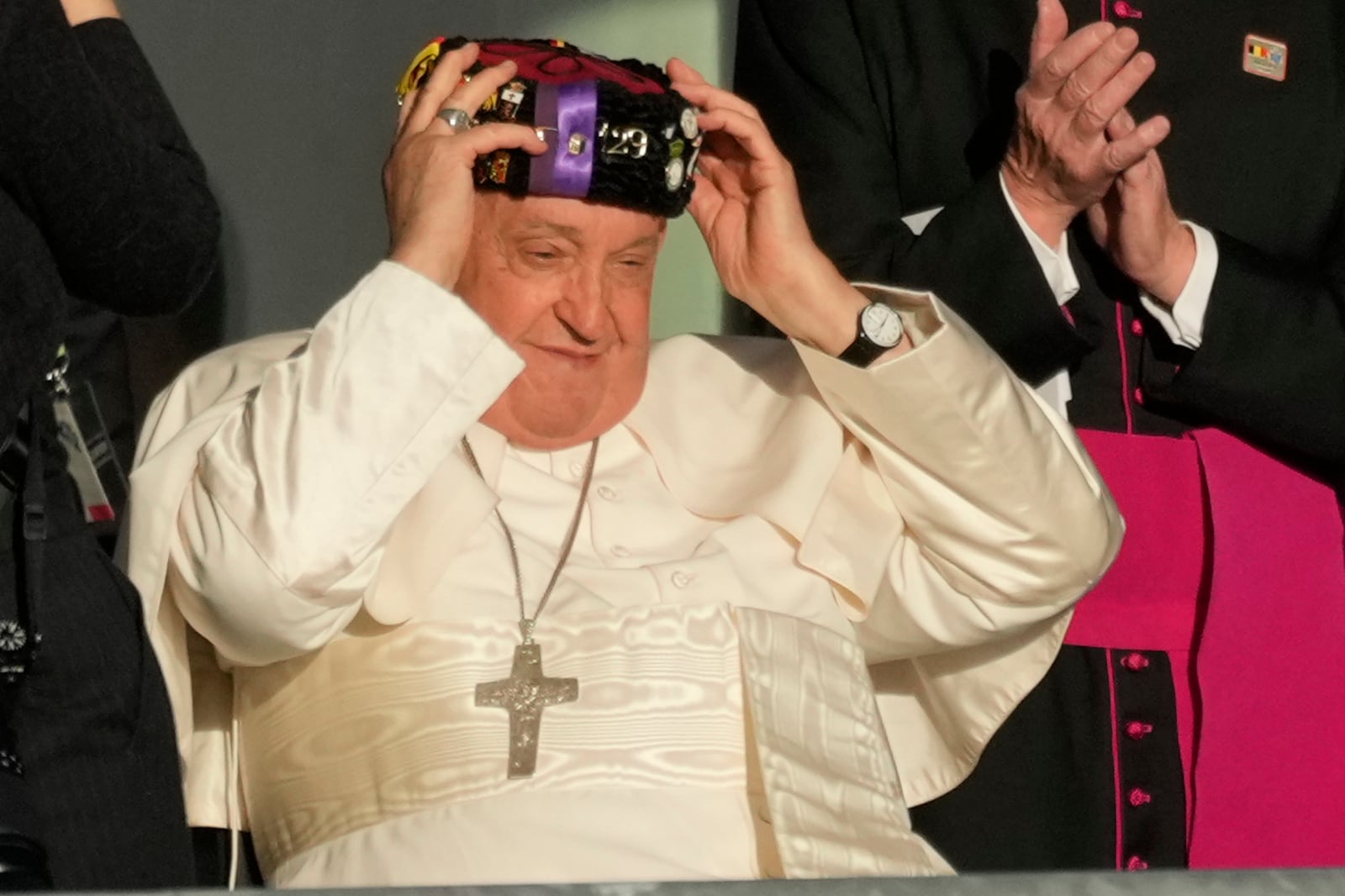 Pope Francis wears a traditional hat at the end of his meeting with students of the Louvain Catholic University in Ottignies-Louvain-la-Neuve, Belgium, Saturday, Sept. 28, 2024. (AP Photo/Andrew Medichini)