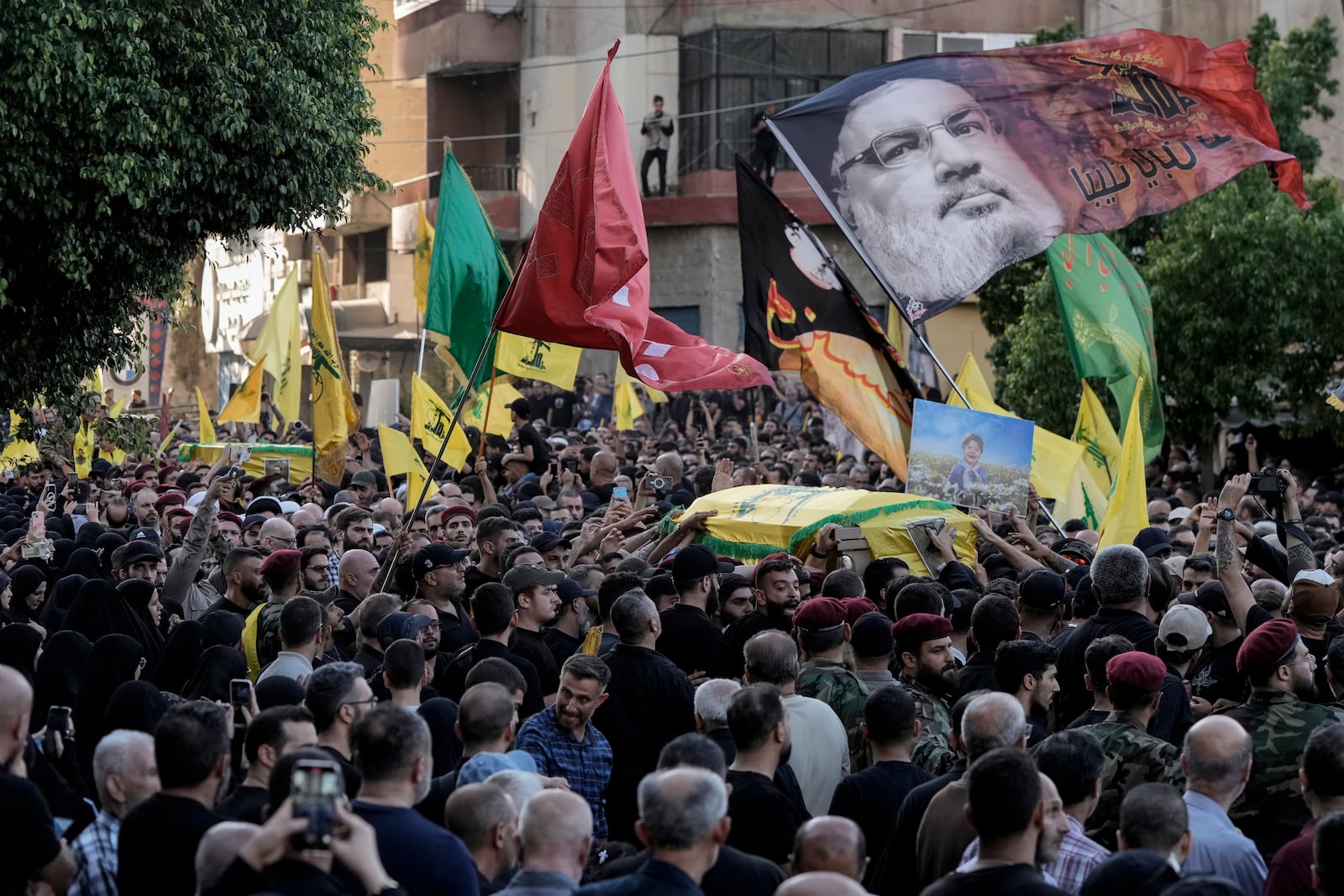 Mourners carry the coffins of Hezbollah fighters who were killed in Friday's Israeli strike, during their funeral procession in the southern suburb of Beirut, Lebanon, Saturday, Sept. 21, 2024. (AP Photo/Bilal Hussein)