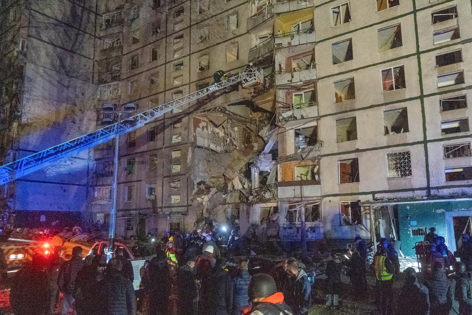 Rescuers help people after a multi-storey apartment building was hit by Russian attack in Kharkiv, Ukraine, late Wednesday, Oct. 30, 2024. (AP Photo/Andrii Marienko)