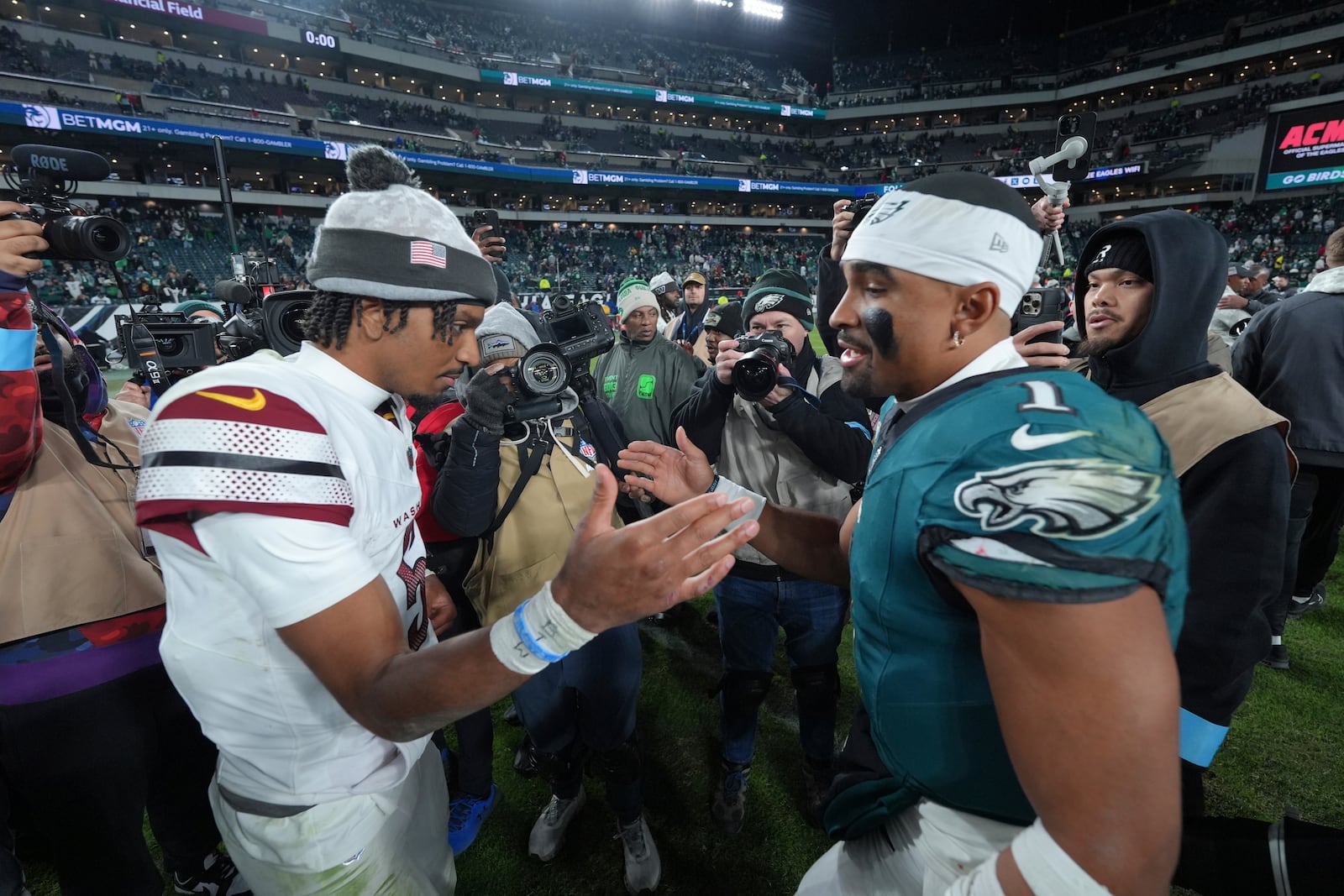 Philadelphia Eagles quarterback Jalen Hurts (1) and Washington Commanders quarterback Jayden Daniels shake hands following an NFL football game Thursday, Nov. 14, 2024, in Philadelphia. The Eagles won 26-18. (AP Photo/Chris Szagola)