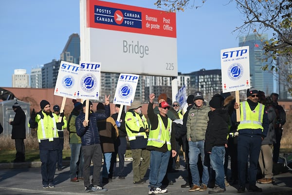 Canada Post workers picket outside a sorting plant in Montreal on Friday, Nov.15, 2024. (Graham Hughes/The Canadian Press via AP)