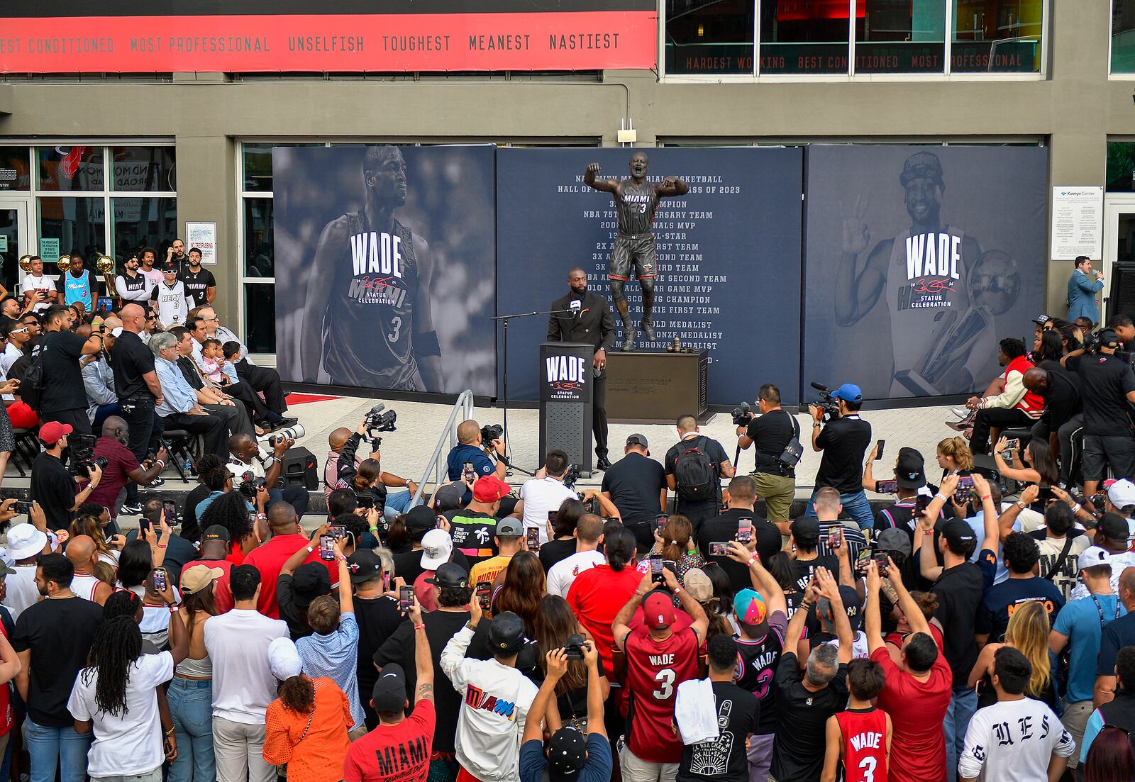 Former Miami Heat NBA basketball player Dwyane Wade, center, speaks during his statue unveiling ceremony outside the Kaseya Center, Sunday, Oct. 27, 2024, in Miami, Fla. (AP Photo/Michael Laughlin)