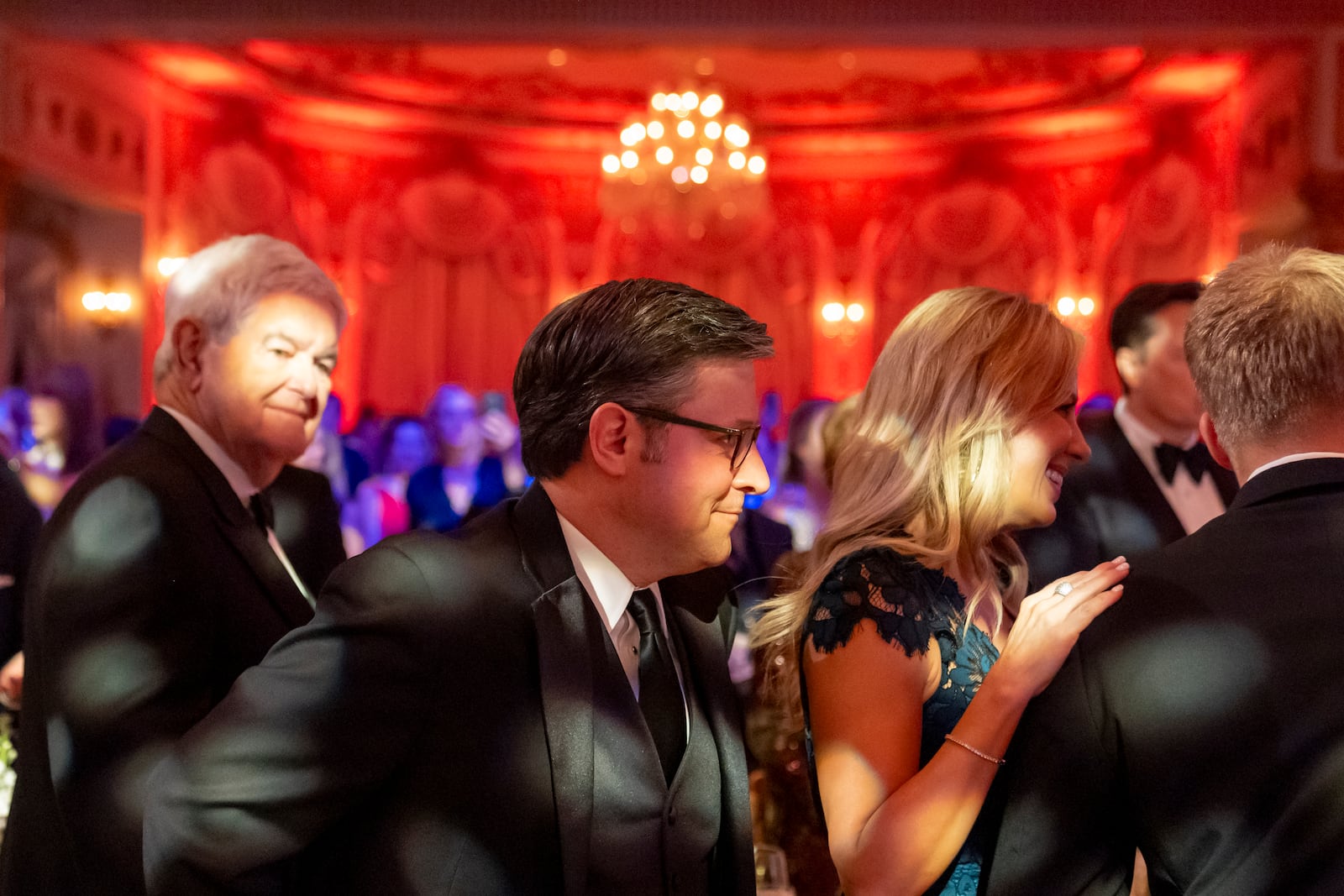 House Speaker Mike Johnson of La.,, center, stands before President-elect Donald Trump speaks during an America First Policy Institute gala at his Mar-a-Lago estate, Thursday, Nov. 14, 2024, in Palm Beach, Fla., as Newt Gingrich, left, watches. (AP Photo/Alex Brandon)