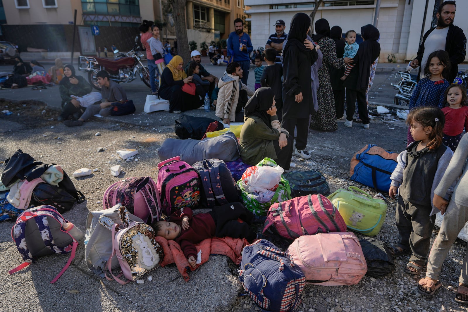 Families gather in Martyrs' square after fleeing the Israeli airstrikes in Beirut's southern suburbs, Saturday, Sept. 28, 2024. (AP Photo/Bilal Hussein)