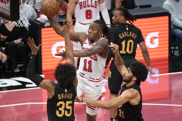 Chicago Bulls' Ayo Dosunmu (11) drives to the basket as Cleveland Cavaliers' Isaac Okoro (35) and Jarrett Allen, front right, defend during the first half of an Emirates NBA cup basketball game in Cleveland, Friday, Nov 15, 2024. (AP Photo/Phil Long)