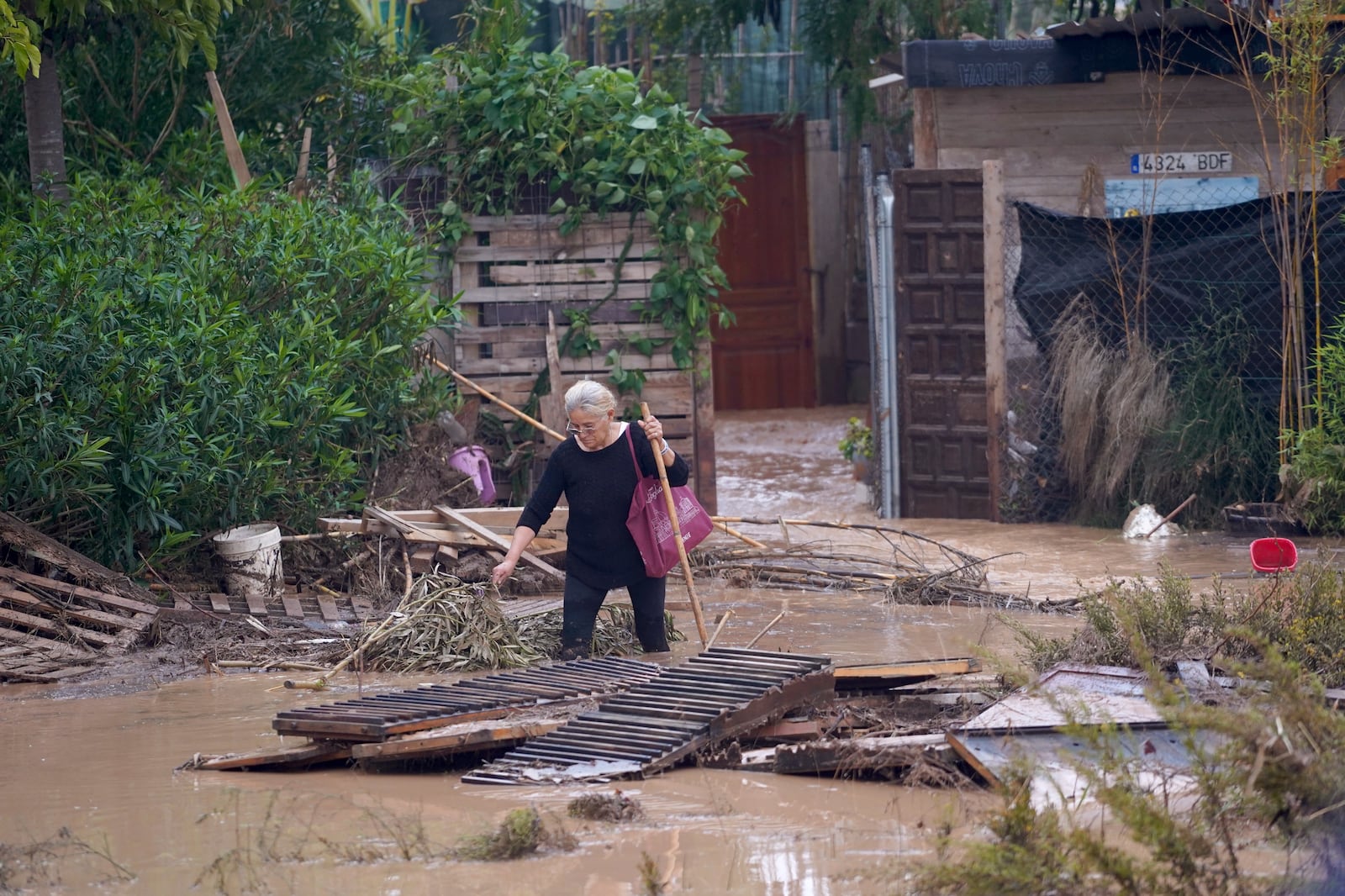 A woman walks through flooded streets in Valencia, Spain, Wednesday, Oct. 30, 2024. (AP Photo/Alberto Saiz)