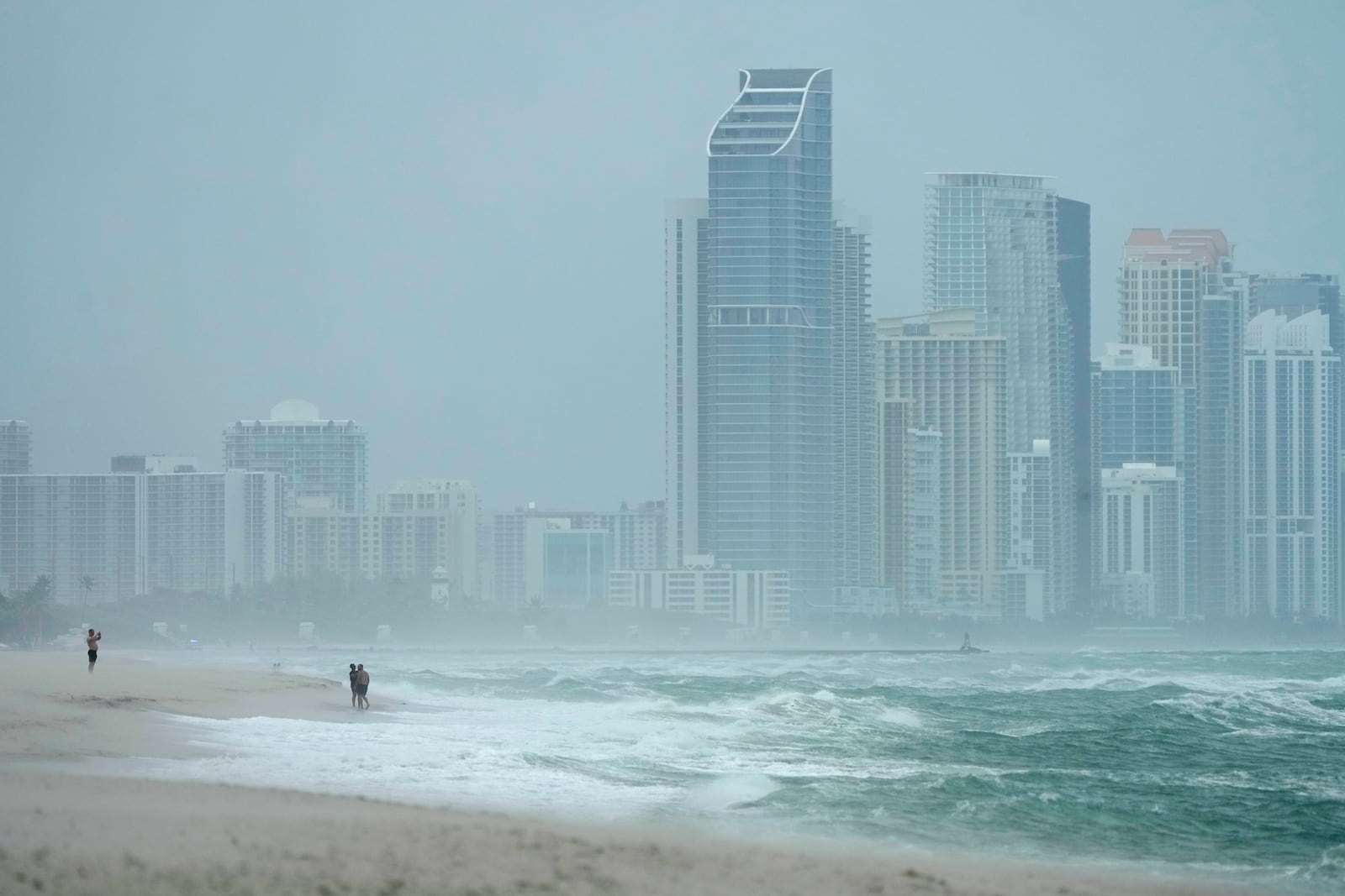 The city of Sunny Isles Beach, Fla., is seen from Surfside, Fla., as the outer bands of Hurricane Milton kick up the sand, Wednesday, Oct. 9, 2024. (AP Photo/Wilfredo Lee)