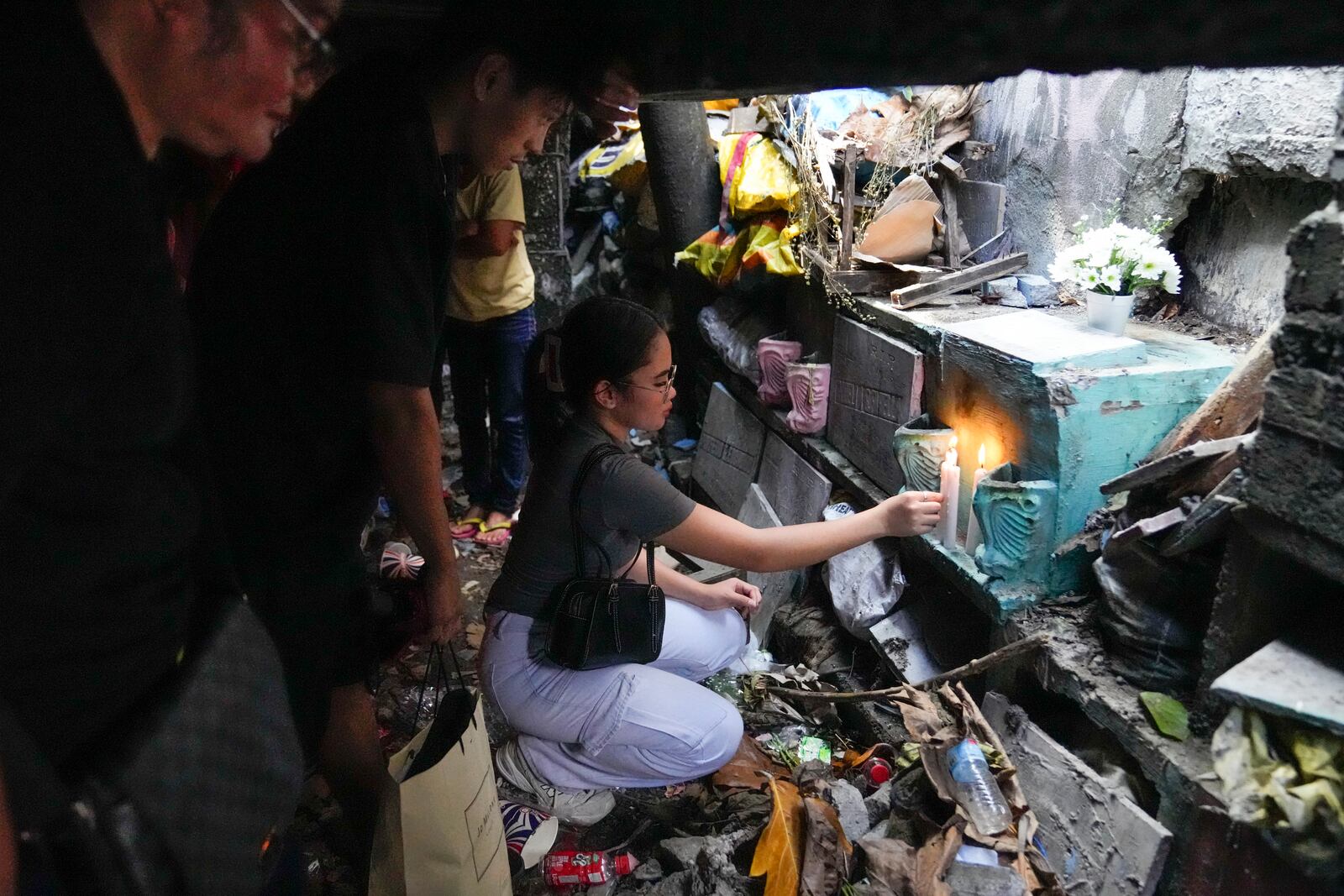 A family lights candles as they visit the tomb of their departed loved one at Manila's North Cemetery, Philippines as the nation observes All Saints Day on Friday, Nov. 1, 2024. (AP Photo/Aaron Favila)