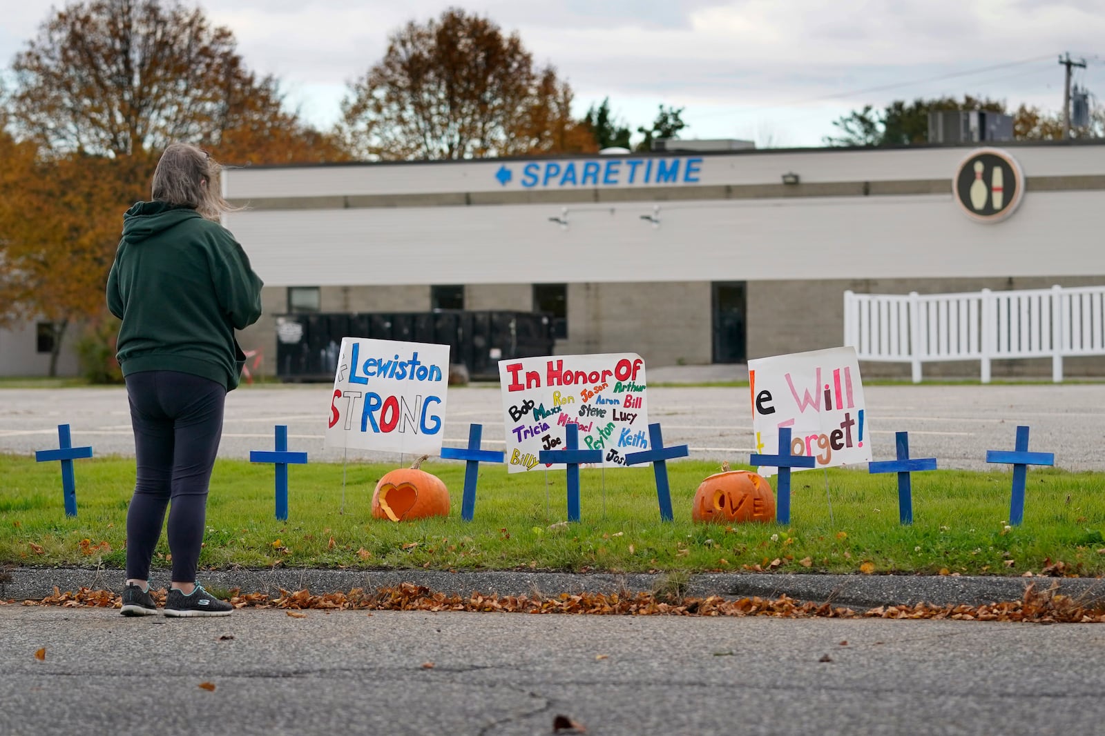 FILE - A woman visits a makeshift memorial outside Sparetime Bowling Alley, the site of a mass shooting, in this Oct. 28, 2023 file photo, in Lewiston, Maine. (AP Photo/Robert F. Bukaty, File)