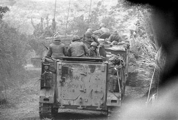 Soldiers of the Americal Divison ride on armored personnel carriers toward Lang Vel Special Forces camp, half a mile from the Laotian border during the Vietnam War, 1971. The Americans had to clear Route 9 to the Laotian border for Operation Lam Son 719, the South Vietnamese invasion into Laos. Photo from one of the last rolls of film before photographer Henri Huet was killed with three other photojournalists covering the operation. (AP Photo/Henri Huet)