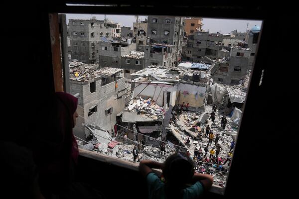 A child and a woman look as Palestinians search the rubble of a house targeted by an Israeli army strike that killed killing at least five members of the Abu Sahloul family in Khan Younis, in the southern Gaza Strip, Thursday, May 1, 2025. (AP Photo/Abdel Kareem Hana)