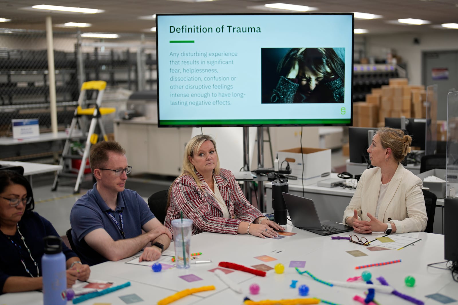 Cari-Ann Burgess, third from left, interim Registrar of Voters for Washoe County, Nev., attends a class on dealing with work stress and trauma with office assistant Shawna Johnson, from left, and business technologist Michael Mulreany, Friday, Sept. 20, 2024, in Reno, Nev. (AP Photo/John Locher)