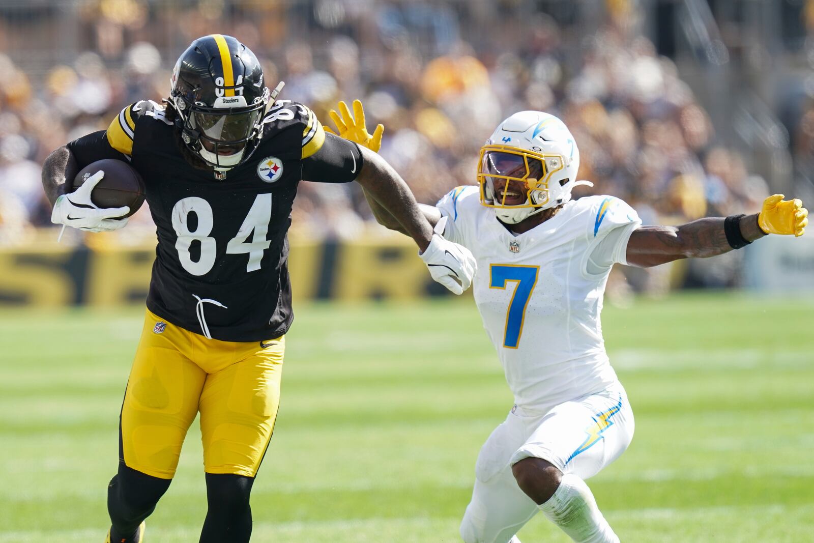 Pittsburgh Steelers running back Cordarrelle Patterson, left, runs with the ball against Los Angeles Chargers cornerback Kristian Fulton, right, during the second half of an NFL football game, Sunday, Sept. 22, 2024, in Pittsburgh. (AP Photo/Matt Freed)