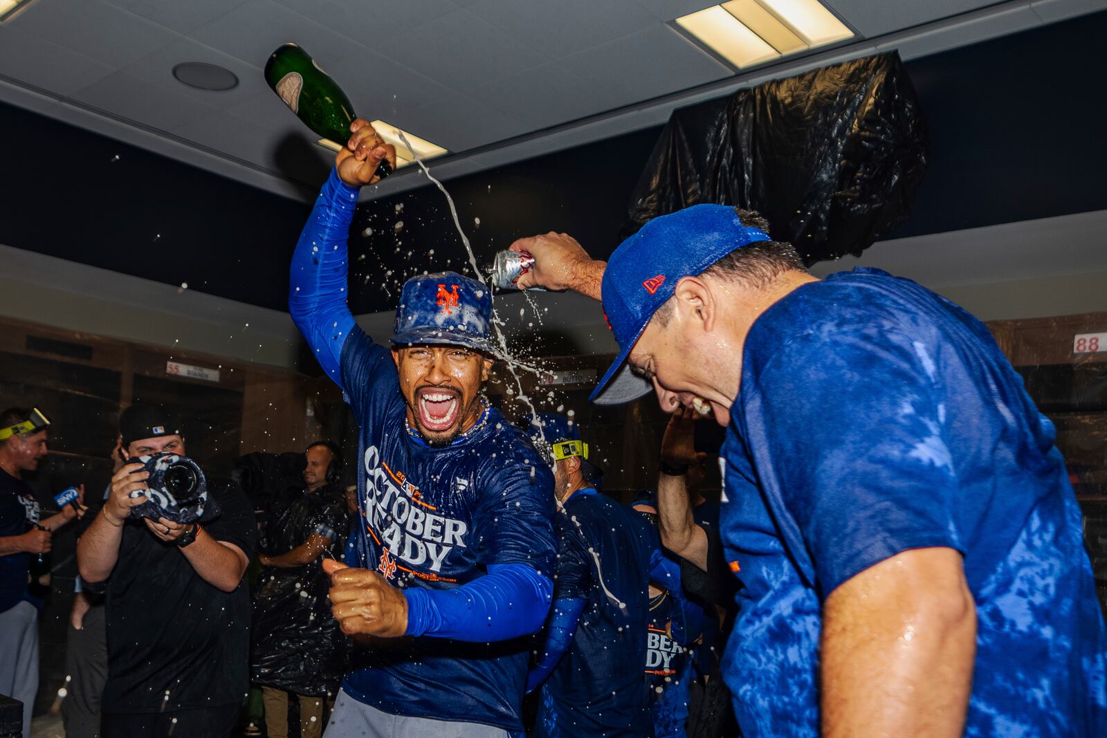 The New York Mets celebrate in the locker room after clinching a playoff berth with a victory in the first game of a doubleheader against the Atlanta Braves, Monday, Sept. 30, 2024, in Atlanta. (AP Photo/Jason Allen)