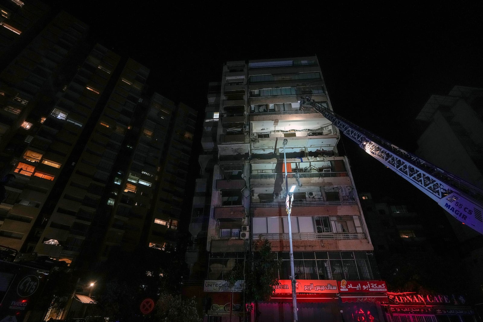 A fire engine ladder extends up a building that was hit in an apparent Israeli airstrike, in central Beirut, Lebanon, early Monday, Sept. 30, 2024. (AP Photo/Bilal Hussein)