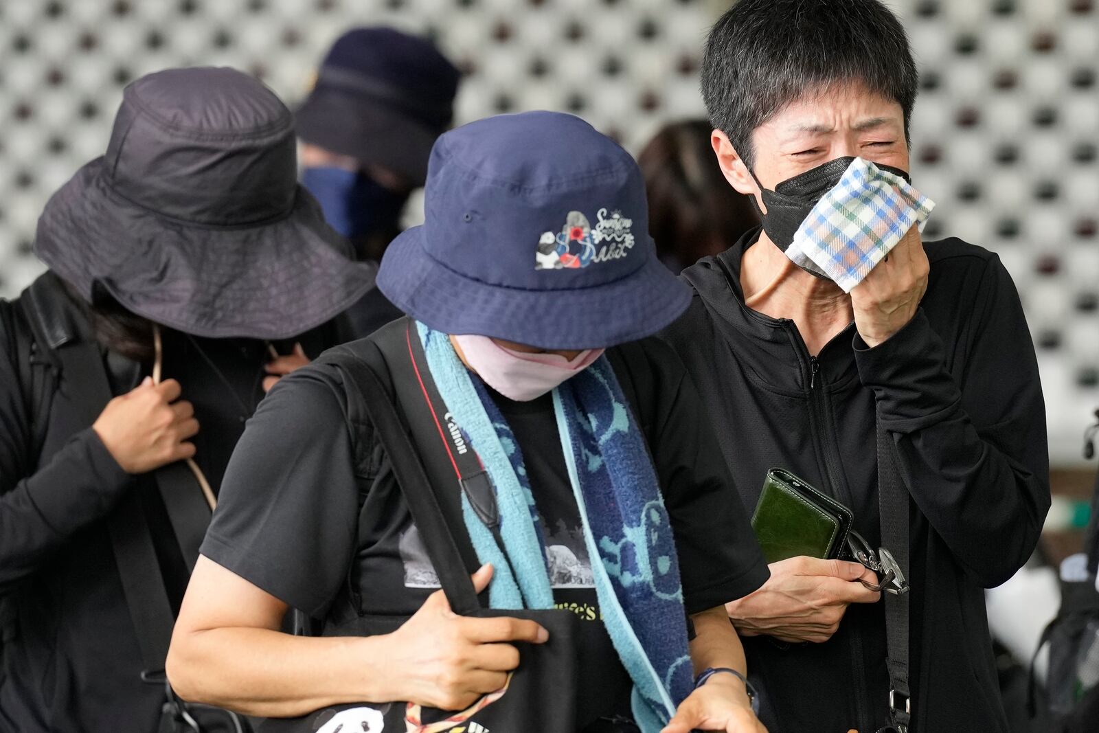 Visitors react after seeing the giant pandas Ri Ri and Shin Shin at Ueno Zoo, a day before their return to China, Saturday, Sept. 28, 2024, in Tokyo. (AP Photo/Eugene Hoshiko)