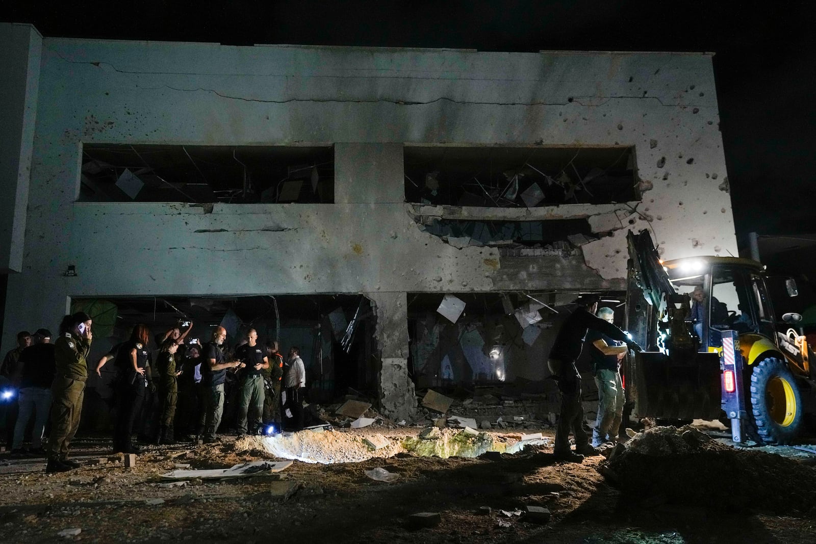 Israeli military and police work at a damaged school building that was hit by missiles fired from Iran in Gadera, Israel, Tuesday, Oct. 1, 2024. (AP Photo/Tsafrir Abayov)