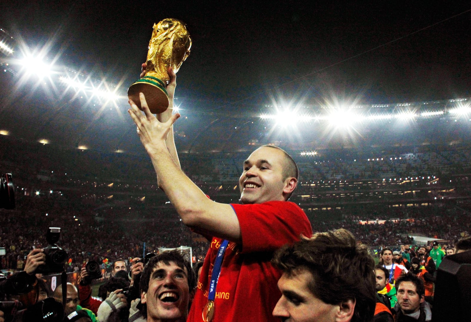 FILE - Spain's Andres Iniesta holds up the World Cup trophy after the World Cup final soccer match between the Netherlands and Spain at Soccer City in Johannesburg, South Africa, July 11, 2010. Andres Iniesta who scored Spain's World Cup-winning goal in 2010 and was one of the key players who made Barcelona's tiki-taka thrive for so long, announced his retirement from soccer on Tuesday. (AP Photo/Bernat Armangue, File)